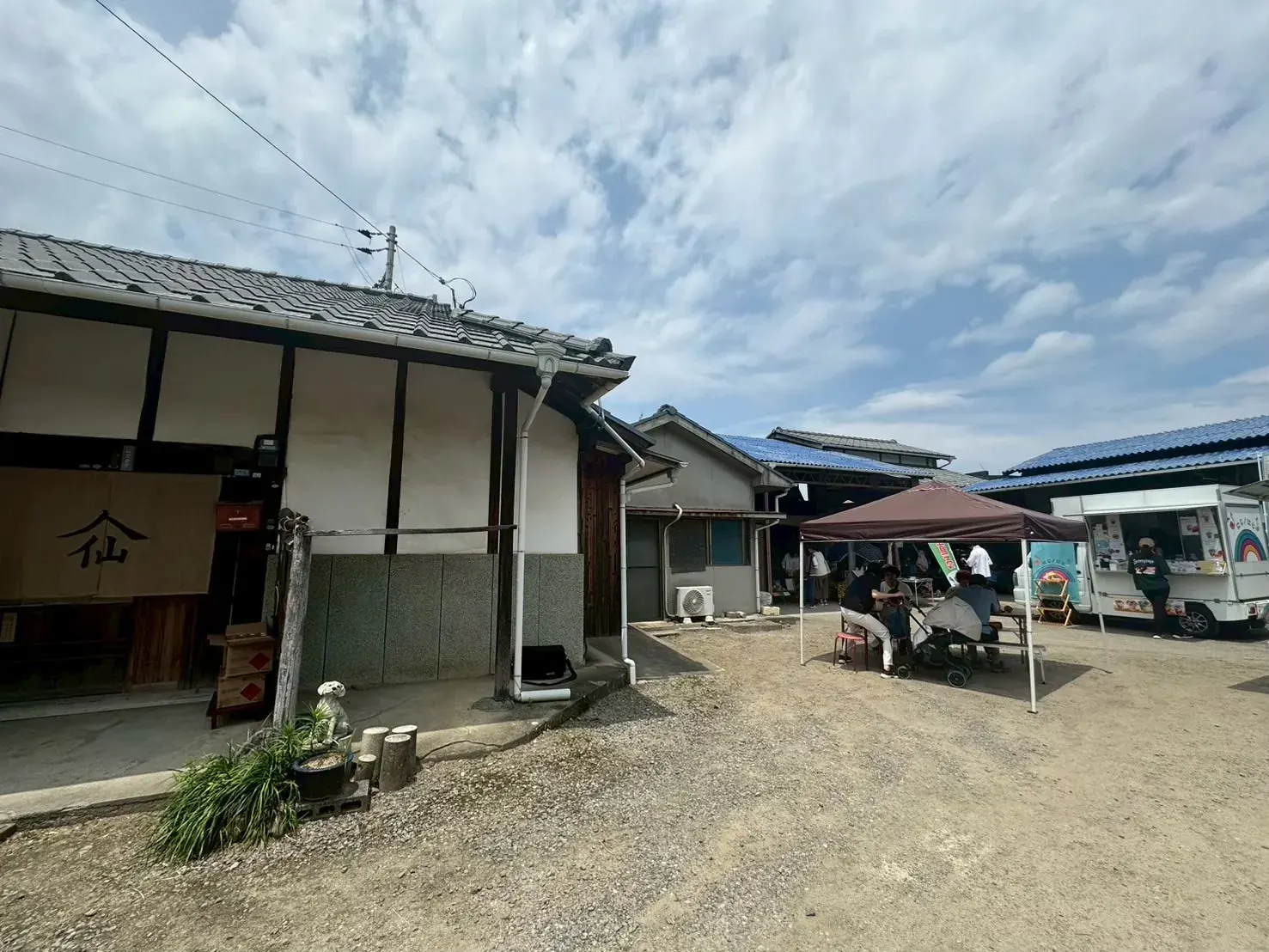 広い庭にテントが立ち並び、離れた棟のあいだで人が集うmagoおおひがしの遠景