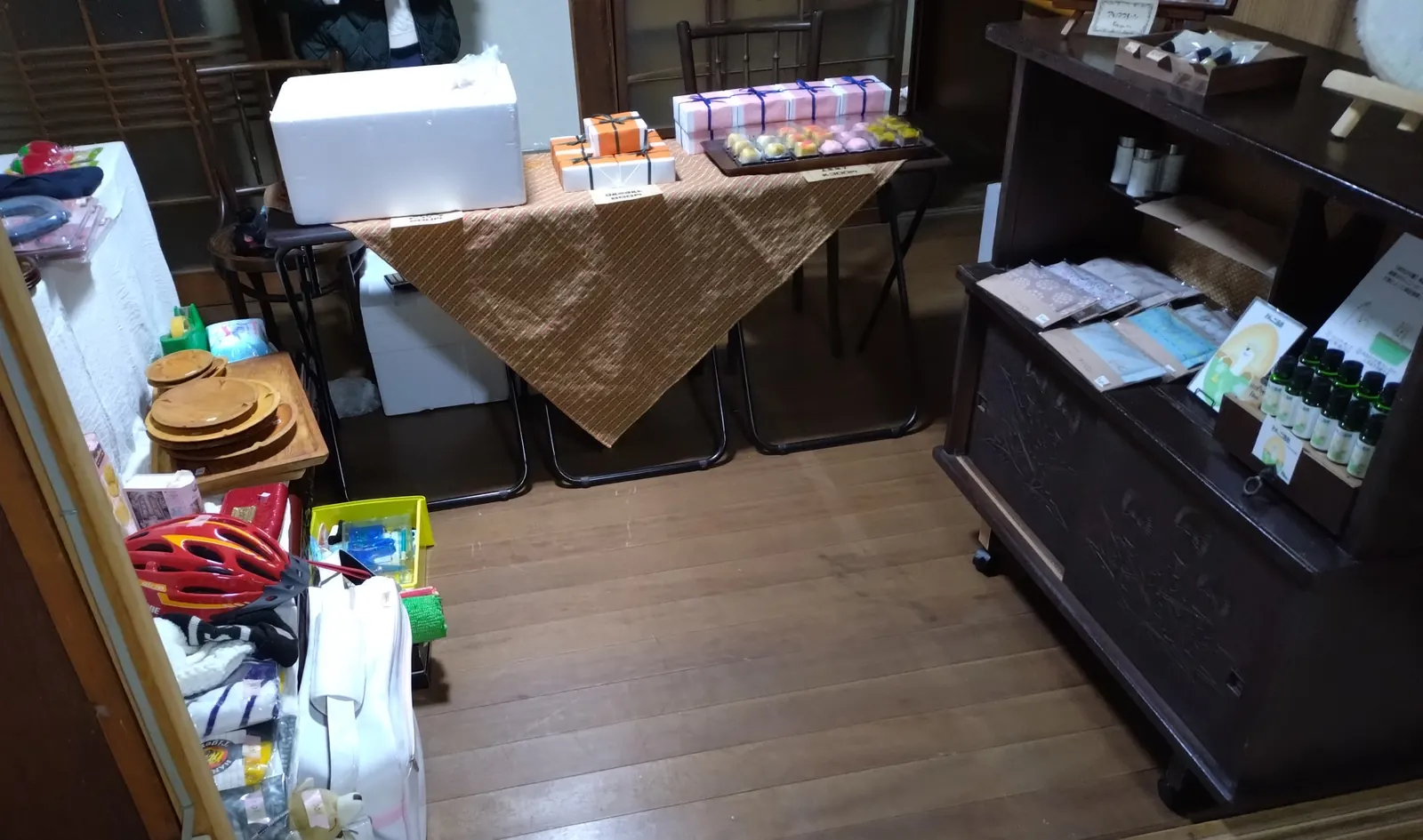 開店前の土間。白い箱や古い家具が並び、まだ人はいない