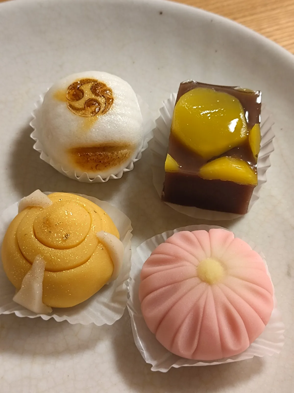 白い皿にのった季節の和菓子。栗や菊をかたどった四種