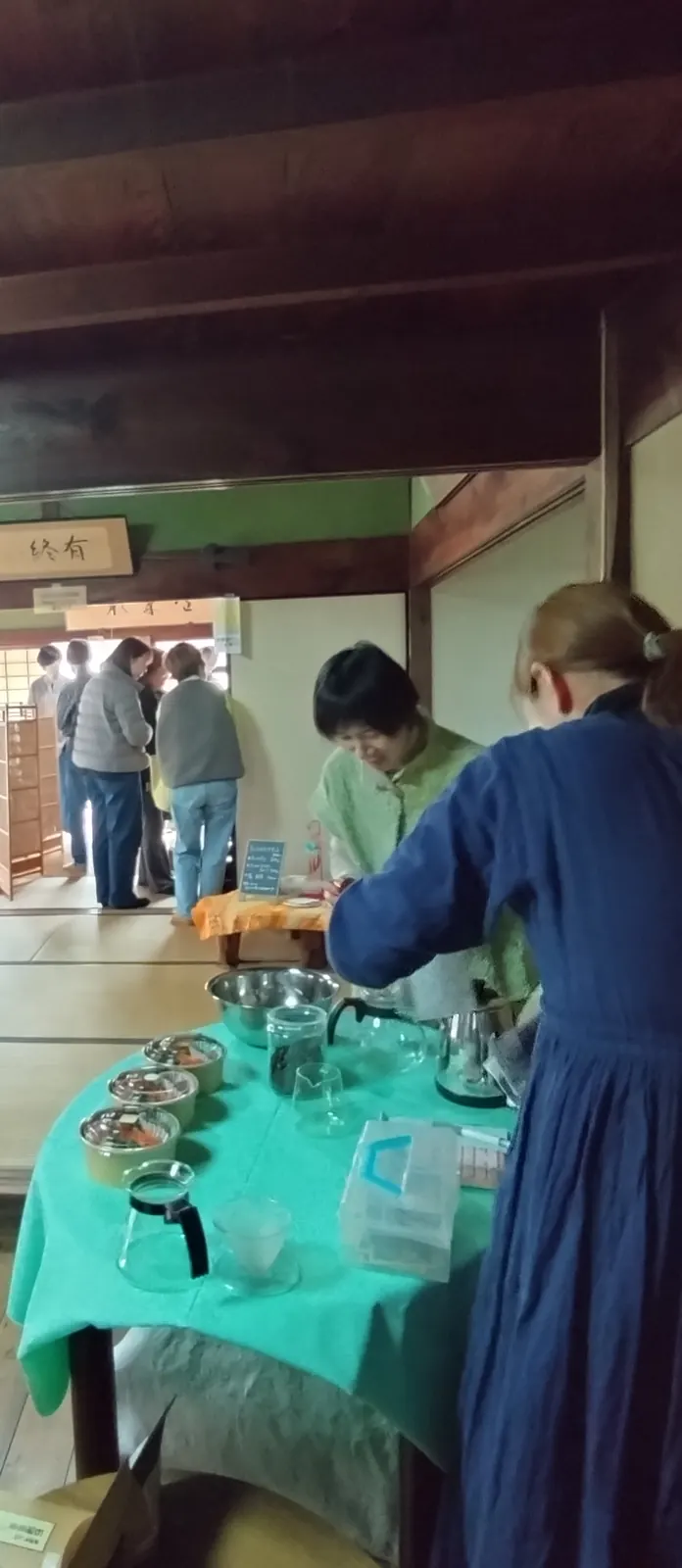 緑のクロスをかけた台に並ぶ、ハーブやオイルらしき瓶