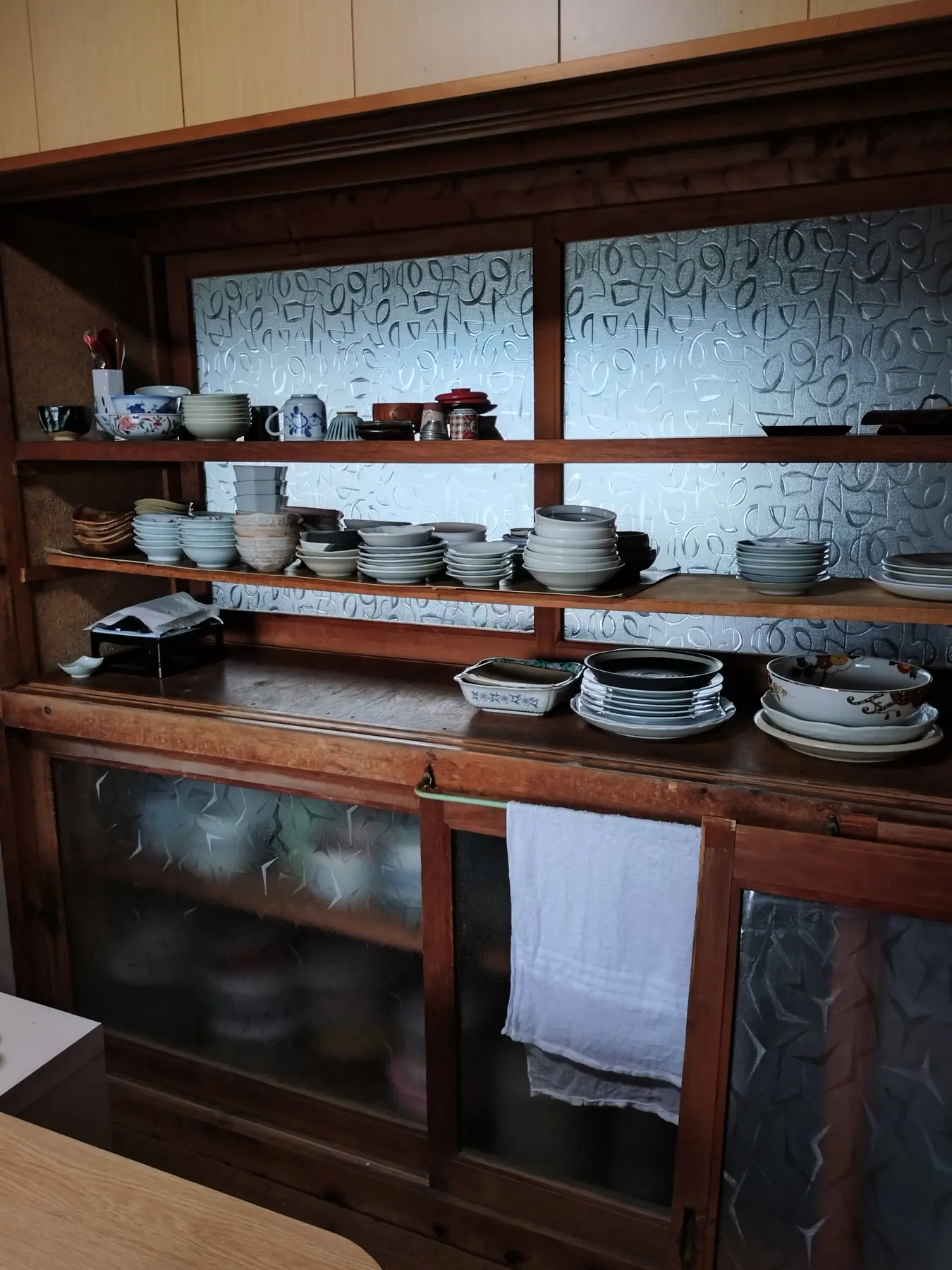 家の古い食器棚。ガラス戸の奥に器が並ぶ